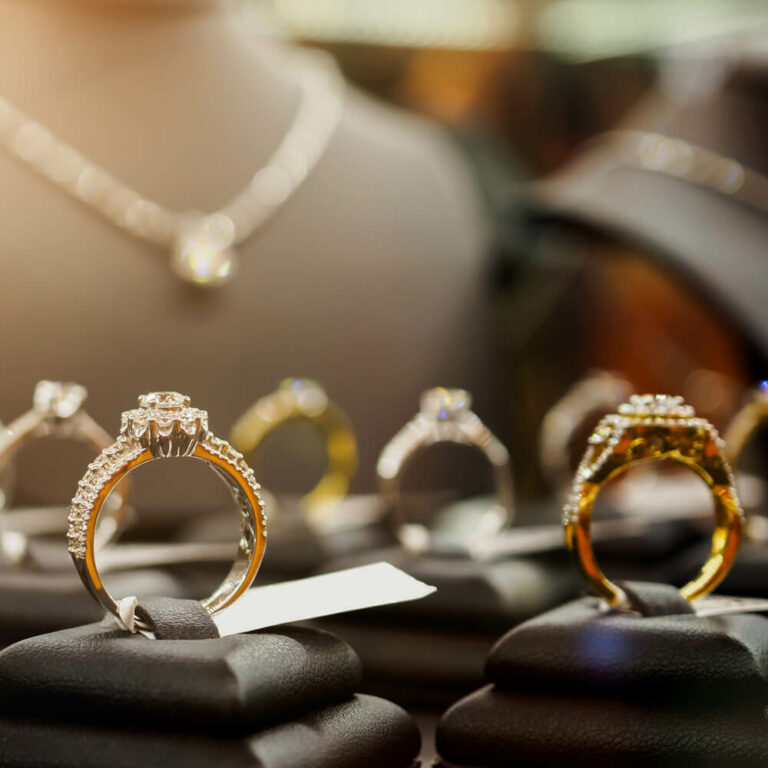 Exklusiver Schmuck: Funkelnde Diamantringe in Gold und Silber präsentiert auf eleganten schwarzen Schmuckständern in unserem Geschäft in Berlin.